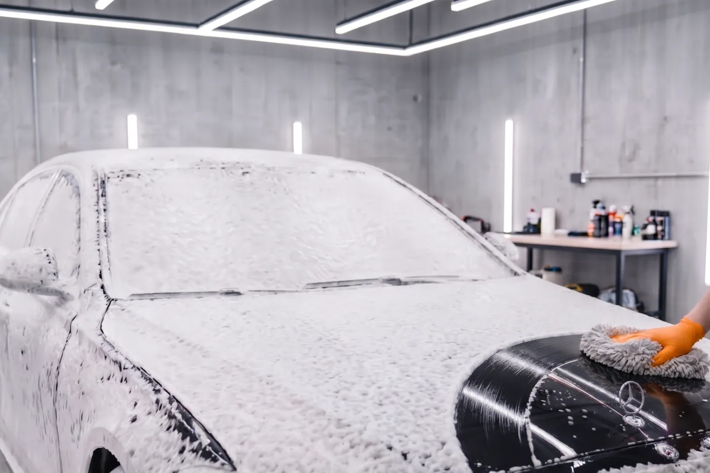 Snow foam running down the side of a black sedan