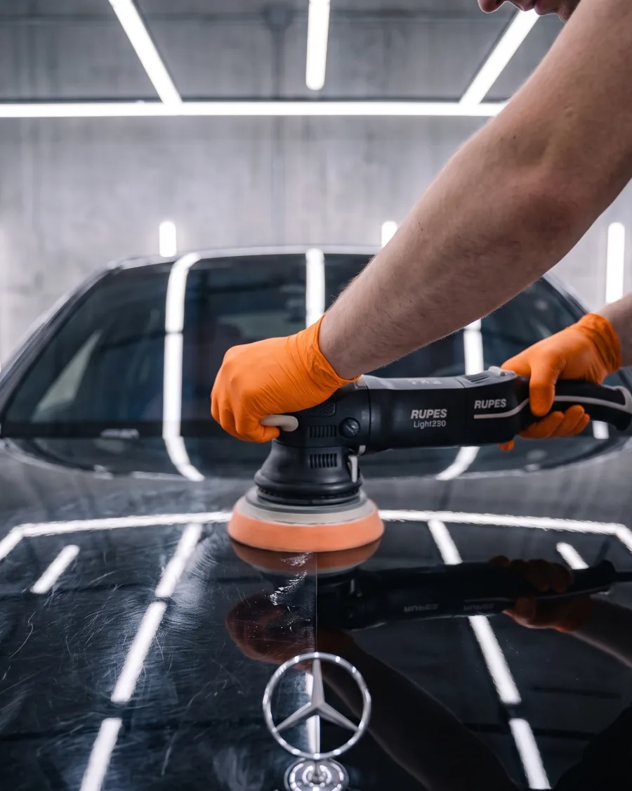 A polisher cutting swirl marks out of black paint